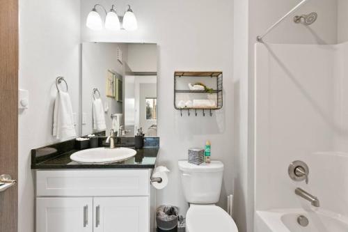 een witte badkamer met een toilet en een wastafel bij New 2 Bed 2 Bath Near Perry Dist and DT in Spokane