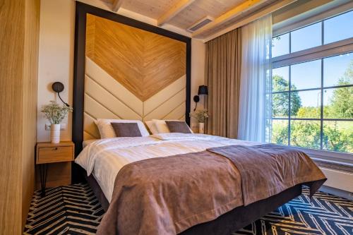 a bedroom with a large bed and a large window at Santa Natura Resort & SPA 