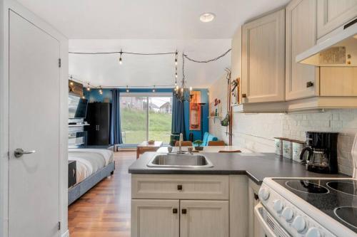 a kitchen with a sink and a bedroom with a bed at Initial / Loft de la montagne / MSA in Saint-Férréol-les-Neiges