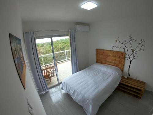 1 dormitorio con 1 cama y puerta corredera de cristal en Boca PentHouses - Tampiquera en Boca del Río