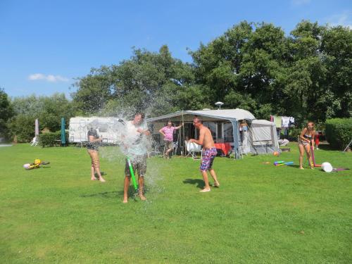 a group of people playing with water in a field at Boerderijcamping Plantlust in Veere