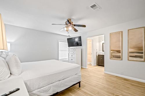 a white bedroom with a bed and a ceiling fan at Lagoon Retreat in Pensacola
