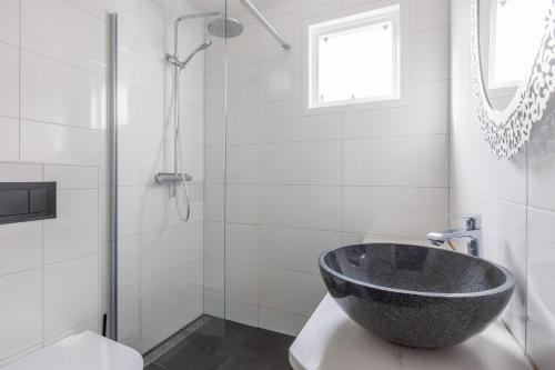 La salle de bains est pourvue d'un lavabo en pierre et d'une douche. dans l'établissement Amelander Kaap 109, à Hollum
