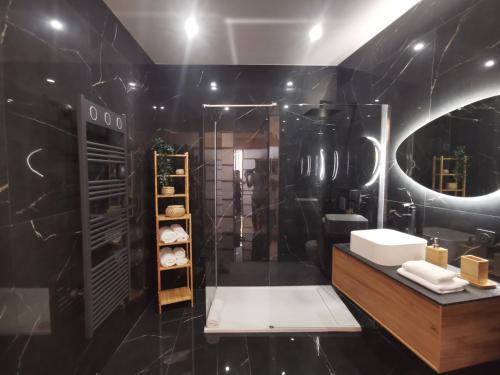 a black bathroom with a sink and a mirror at Proche mer, vieille ville. Luxueux appartement in Villefranche-sur-Mer