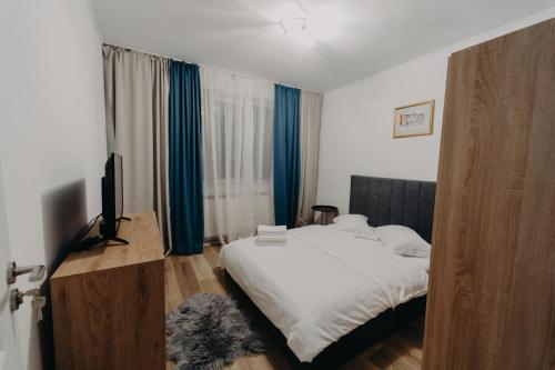 a bedroom with a bed and a television in it at Apartamentul Albastru in Vatra Dornei