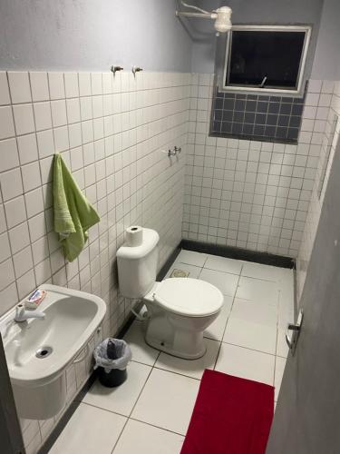 een witte badkamer met een toilet en een wastafel bij Ed Bertholi - Vista lateral do mar com garagem in Serra