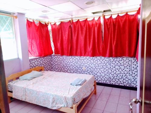 Schlafzimmer mit einem Bett und roten Vorhängen in der Unterkunft Casa sanacion Elixir in Pucallpa