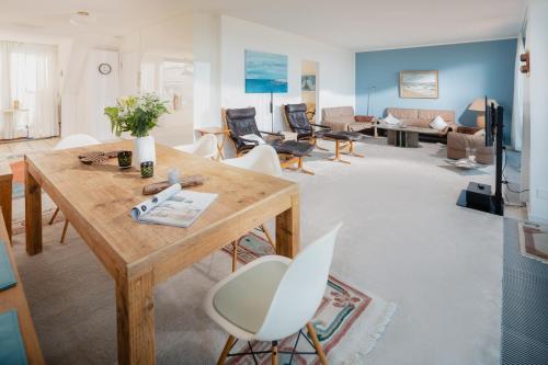 Una sala de estar con una mesa y sillas de madera. en Kaiserblick Norderney, en Norderney