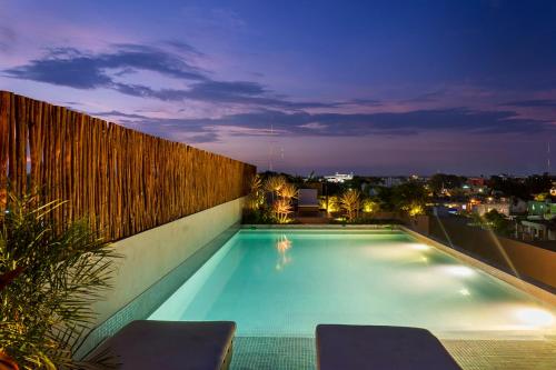 a swimming pool on the roof of a building at night at UJO Condo Boutique in Tulum