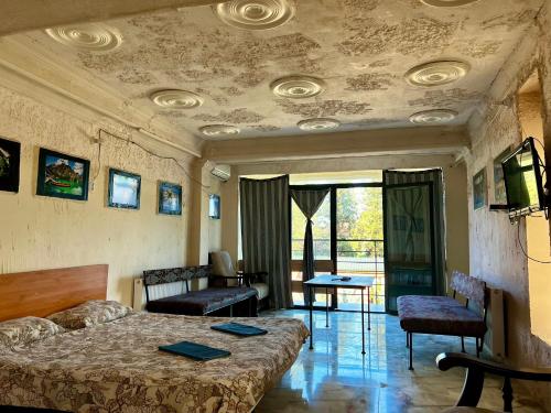 1 dormitorio con 1 cama, mesa y sillas en Smile Guesthouse en Tiflis