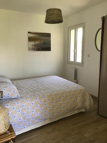 a bedroom with a bed and a window at Charmante Cabane Bois in Gujan-Mestras