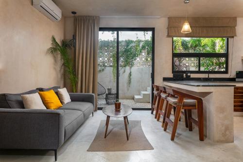 a kitchen and living room with a couch and a table at UJO Condo Boutique in Tulum