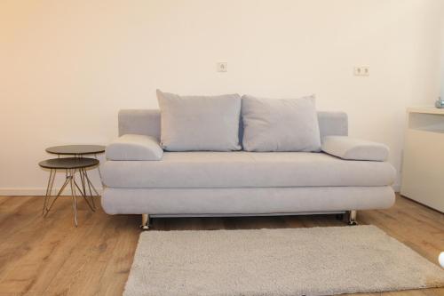 a couch sitting in a living room with a table at Looks Inn in Heidelberg