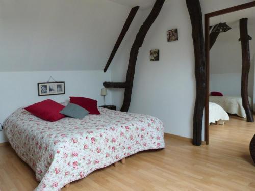 une chambre avec un lit avec des oreillers rouges dans l'établissement Gîte et Relais Equestre de Marie, à Tours-en-Vimeu