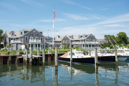 two boats docked at a dock in front of houses at White Elephant Hotel in Nantucket