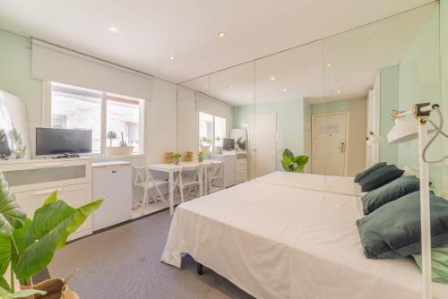 una camera con un grande letto bianco e una cucina di AmazINN Places Gran Via III a Madrid