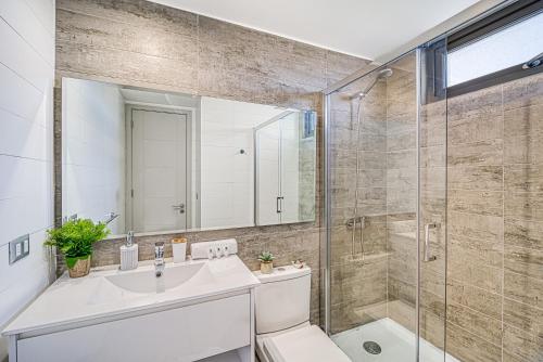 Un baño con lavabo y ducha de cristal. en Galerna Home 2BR W/Balcony, Wifi & Parking., en Concón