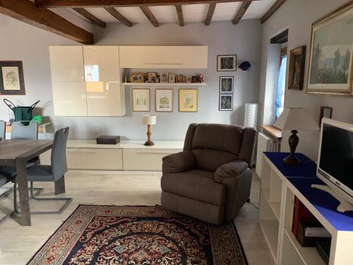 a living room with a chair and a table at Confortevole casa di montagna- La Campana in San Marcello Pistoiese