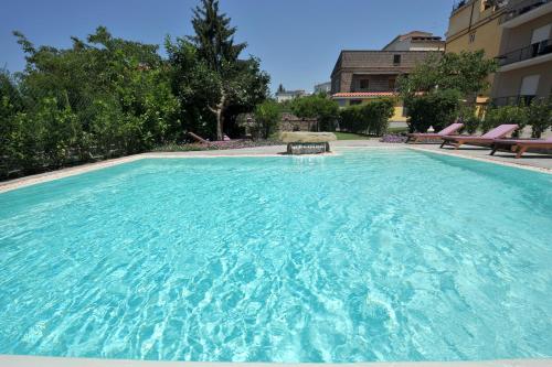 a large pool with blue water in a building at Residenza Villa Titina in SantʼAgata sui Due Golfi