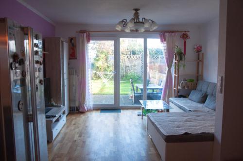 uma sala de estar com um sofá e uma grande porta de vidro deslizante em Elinor‘s House em Flörsheim