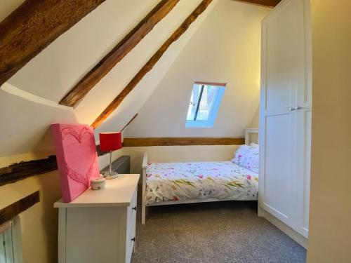 a bedroom with a bed and a desk and a window at The Granary in Little Chart