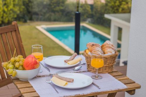 a table with food and a basket of fruit and juice at 188 Apartments - Petúnia - Pool and Balcony in Cascais
