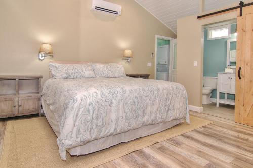 a bedroom with a large bed and a bathroom at SeaSpray Beach Cottage A in St. Pete Beach