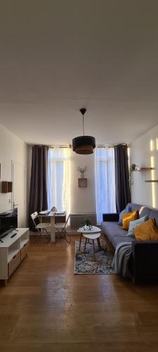 ein Wohnzimmer mit einem Sofa und einem Tisch in der Unterkunft Cosy Studio au coeur de Rouen in Rouen