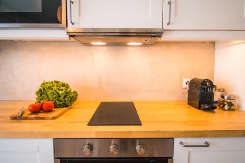 a kitchen counter with a cutting board with vegetables on it at 188 Apartments - Petúnia - Pool and Balcony in Cascais