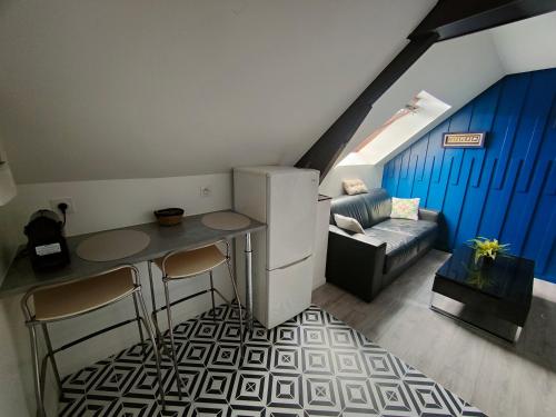 a living room with a refrigerator and a table and a couch at Les Lofts De Provins: Apt 6 in Provins