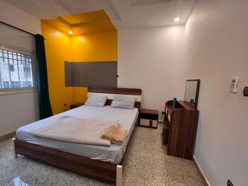 a small bedroom with a bed and a mirror at SMB-gn RÉSIDENCE LAMBANDJI in Conakry