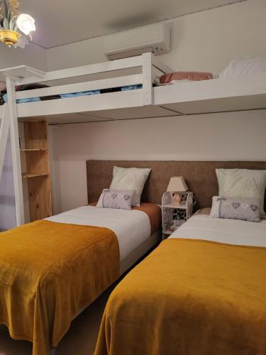 two beds in a room with two bunk beds at Chambre d hôtes AU CŒUR DES OLIVIERS in Marseille