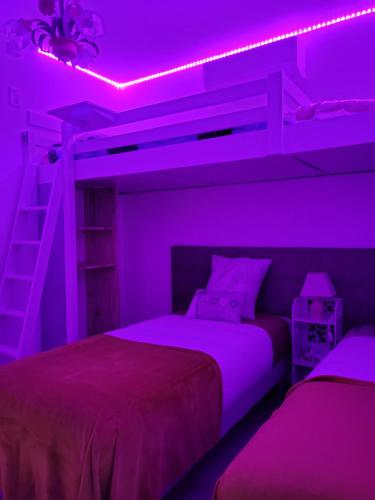 um quarto roxo com 2 camas e uma escada em Chambre d hôtes AU CŒUR DES OLIVIERS em Marselha