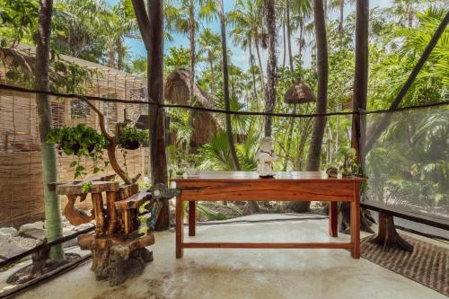 Yaxchen Tulum Cabañas & Cenote في تولوم: غرفة مع طاولة وبعض الأشجار