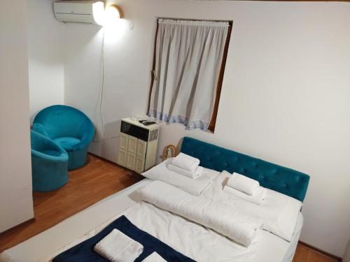 - un salon avec un lit et une chaise bleue dans l'établissement Florida Resort, à Bačka Palanka