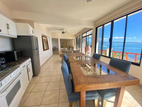 a kitchen with a table and chairs and a kitchen with the ocean at Villa Paraíso in La Ventana