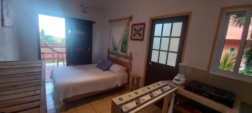 a small bedroom with a bed and a balcony at Casa Gio in Puerto Escondido