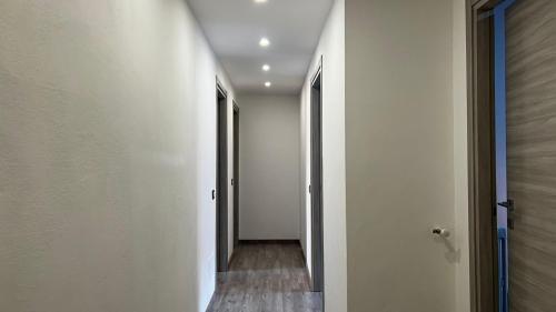 an empty hallway with white walls and wooden floors at A.P. Appartamento o camera in Corsico