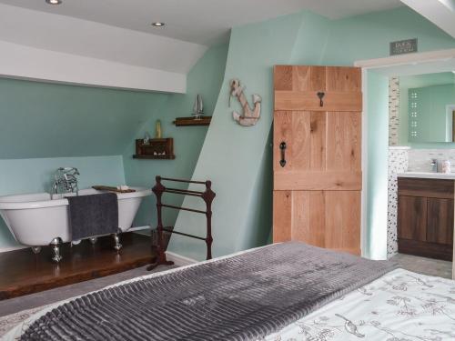 a bedroom with a tub and a sink and a bed at Bay Cottage in Cayton