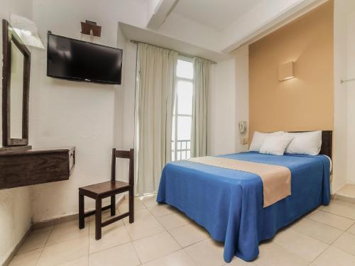 1 dormitorio con 1 cama y TV en la pared en Hotel Trianon, en Veracruz