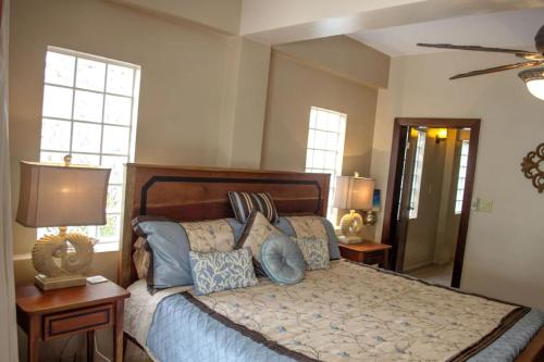 1 dormitorio con 1 cama grande con almohadas azules en Placencia Pointe Townhomes #7 en Placencia Village