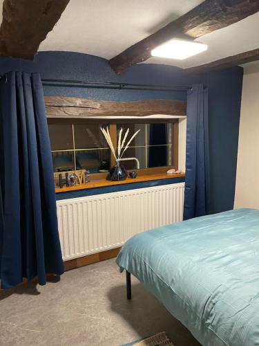 a bedroom with a bed and a window with blue curtains at Casa Wellness Floreffe jacuzzi in Floreffe