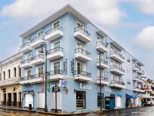 a blue building with balconies on a street at Hotel Trianon in Veracruz