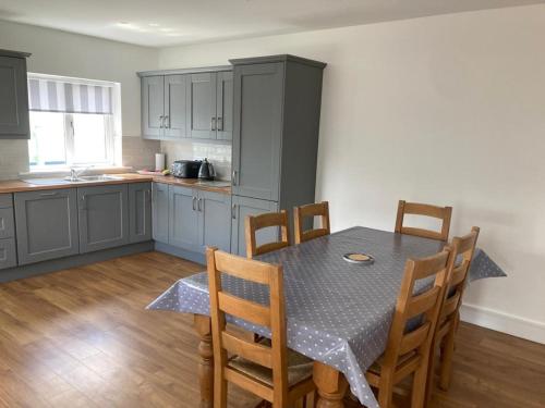 a kitchen with a table and chairs in a room at No. 21 An t'Oileán in Valentia Island