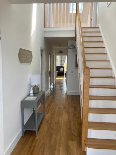 a hallway of a house with a staircase and a table at No. 21 An t'Oileán in Valentia Island