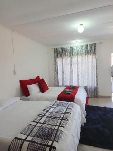 a bedroom with two beds and a window at Casa Línda Guest House in Newcastle