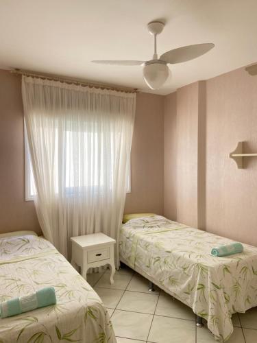 Giường trong phòng chung tại Lindo e aconchegante apto em Jurerê