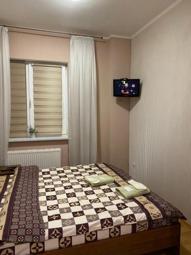 a bedroom with a bed with a tv on the wall at Відпочинковий комплекс,міні готель Старий дворик in Lviv