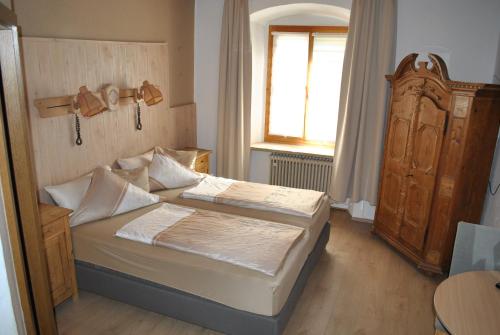 Habitación pequeña con 2 camas y ventana en Gasthof Schwarzer Adler en Nabburg