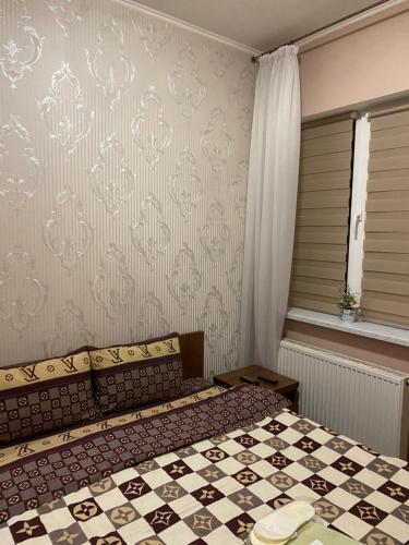 a bedroom with a bed with a checkeredkered at Відпочинковий комплекс,міні готель Старий дворик in Lviv